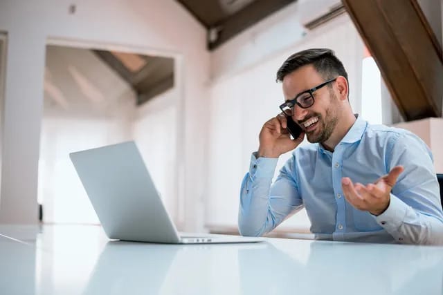 Man on the phone at his computer